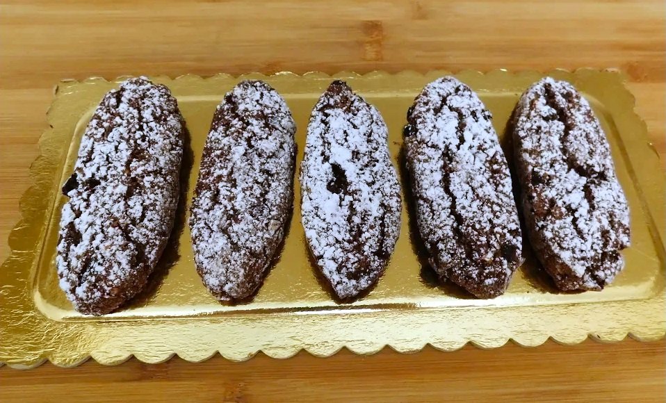 Pan dei Morti su vassoio, biscotti ovali al cacao con frutta secca e vino dolce, dolce tradizionale lombardo per Ognissanti.