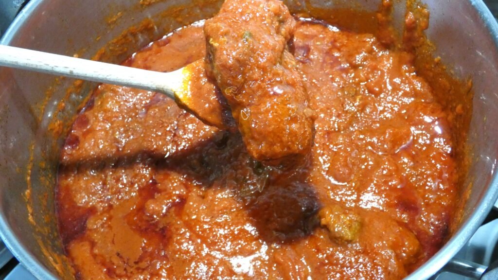 Ragù napoletano di Zia Franca che cuoce lentamente nella pentola, ricetta tradizionale della domenica